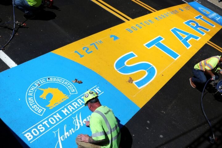 James Sawler, of RoadSafe Traffic Systems, paints the starting line for the 2023 Boston Marathon