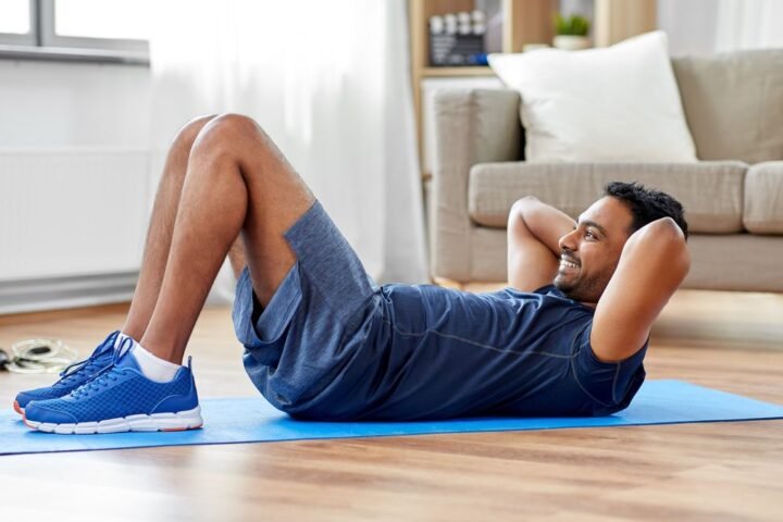 Man performs crunch in his living room