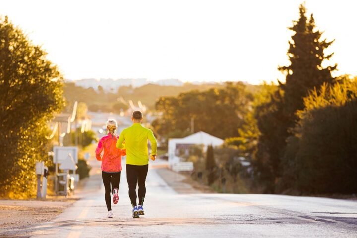 Man and woman seen from rear running downhill