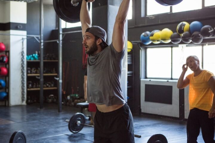 A man performing a thruster with a barbell